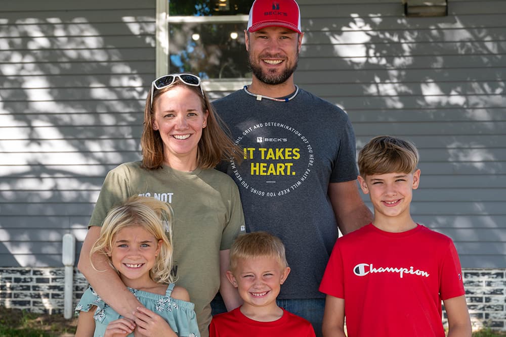 Family with young children poses on farm
